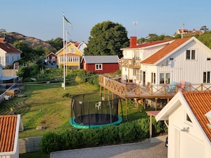 Un quartier résidentiel avec des maisons, un trampoline et un drapeau.