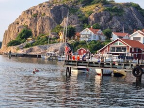 Une propriété située au bord de l’eau, dotée d’un quai, de bateaux et de maisons aux toits rouges.