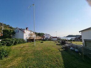 Un barrio residencial con casas, un jardín con césped y cielo despejado.