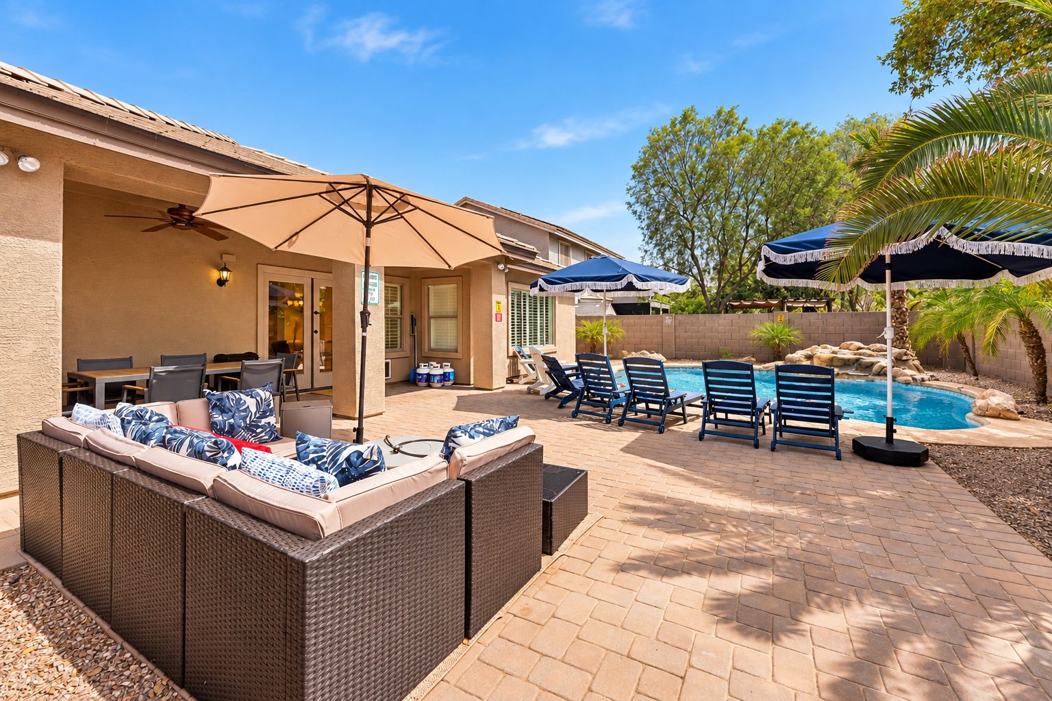 Eine Terrassenanlage mit Pool, Liegestühlen und einer überdachten Sitzgelegenheit.