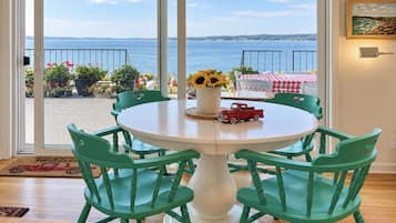 A round table with six chairs, a vase with sunflowers, and a toy truck on the table.
