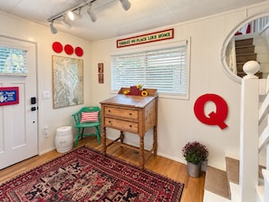 A room with a wooden desk, a red 'Q' wall decoration, a map, and a staircase. - Baby Island Bungalow (Langley)