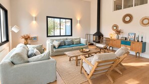 A modern living room with a sofa, chairs, a coffee table, and a fireplace. - Stunning architect-designed villa (LA COUARDE SUR MER)