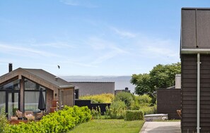 A residential area with a modern house featuring large windows and a patio with outdoor furniture. - Stunning home in Haderslev with WiFi (Haderslev)