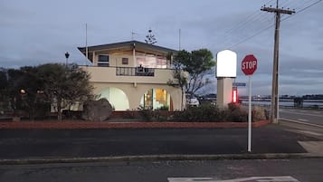 Un edificio de dos pisos con un balcón, una señal de stop y un cartel de 'No Vacantes'.