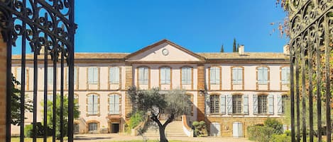 A building with a symmetrical facade, arched windows, and a central entrance with steps leading up to it.