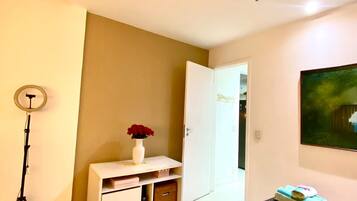 A bedroom with a bed, a dresser, a door, and a painting on the wall.