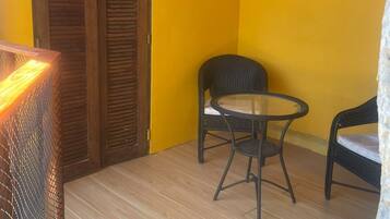 A room with a wooden door, a round table with two chairs, and a yellow wall with decorative stickers.