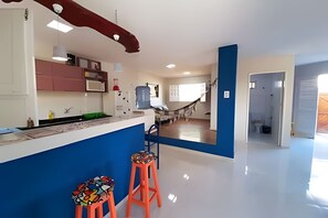 A modern kitchen with a central island, bar stools, and a hammock. - Porto de Galinhas Maraca 100mMar Loctemp (Ipojuca)