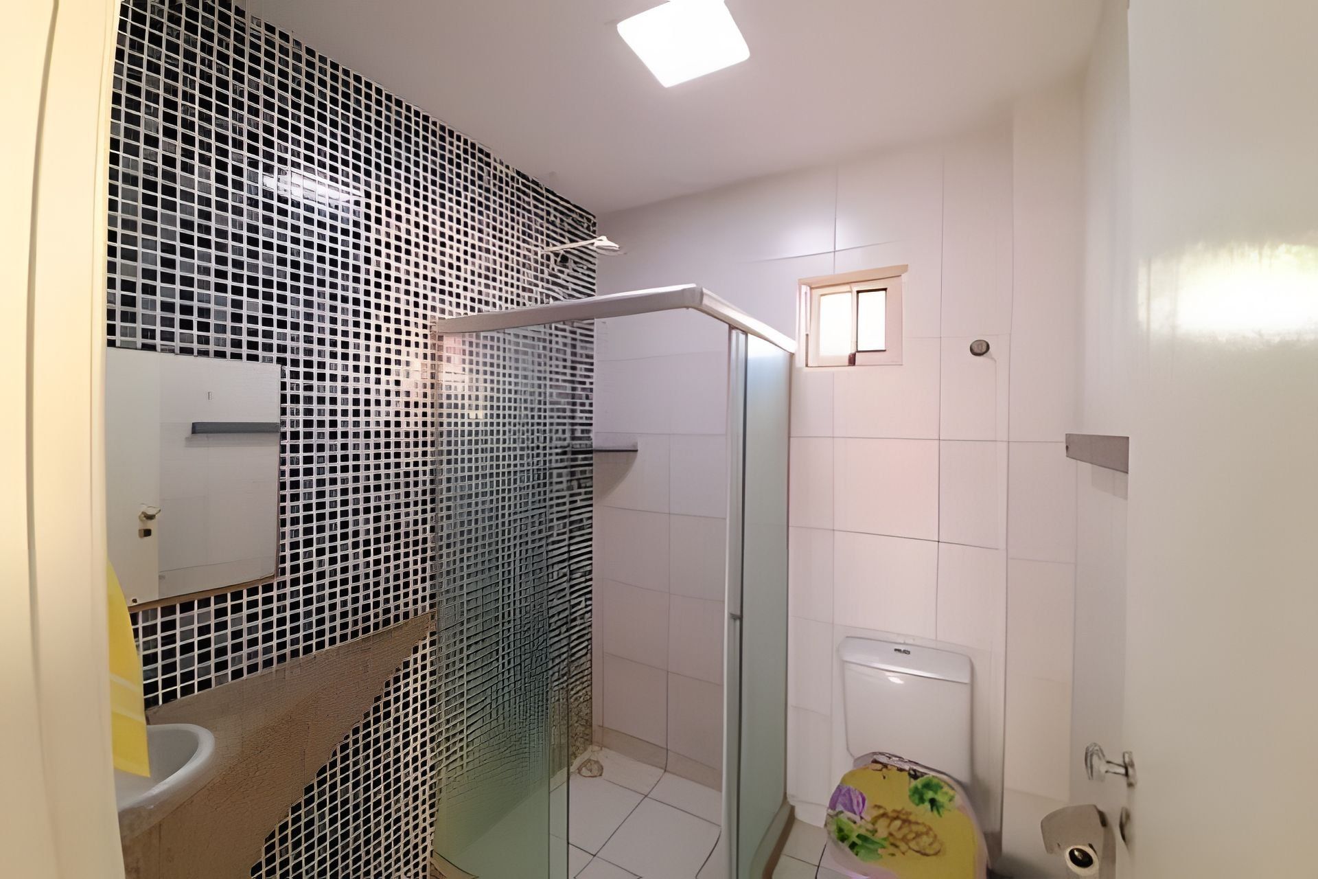 Een badkamer met douche, toilet en wastafel.