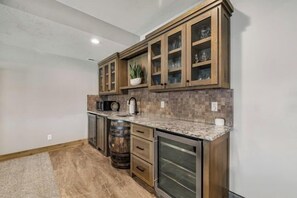 Una cocina con gabinetes de madera, encimera de granito y un barril.