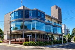Un immeuble moderne à plusieurs étages, doté de grandes fenêtres en verre et d’un toit plat.