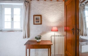 A room with a wooden table, a radiator, a framed picture, and a door. - 1 bedroom amazing home in Poggibonsi (Poggibonsi)
