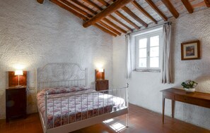 A bedroom with a bed, bedside lamps, a window with curtains, a wooden table, and a wall-mounted picture. - 1 bedroom amazing home in Poggibonsi (Poggibonsi)