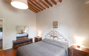 Ein Schlafzimmer mit einem Bett, einem Schminktisch, einem Spiegel und einem Wandbild.