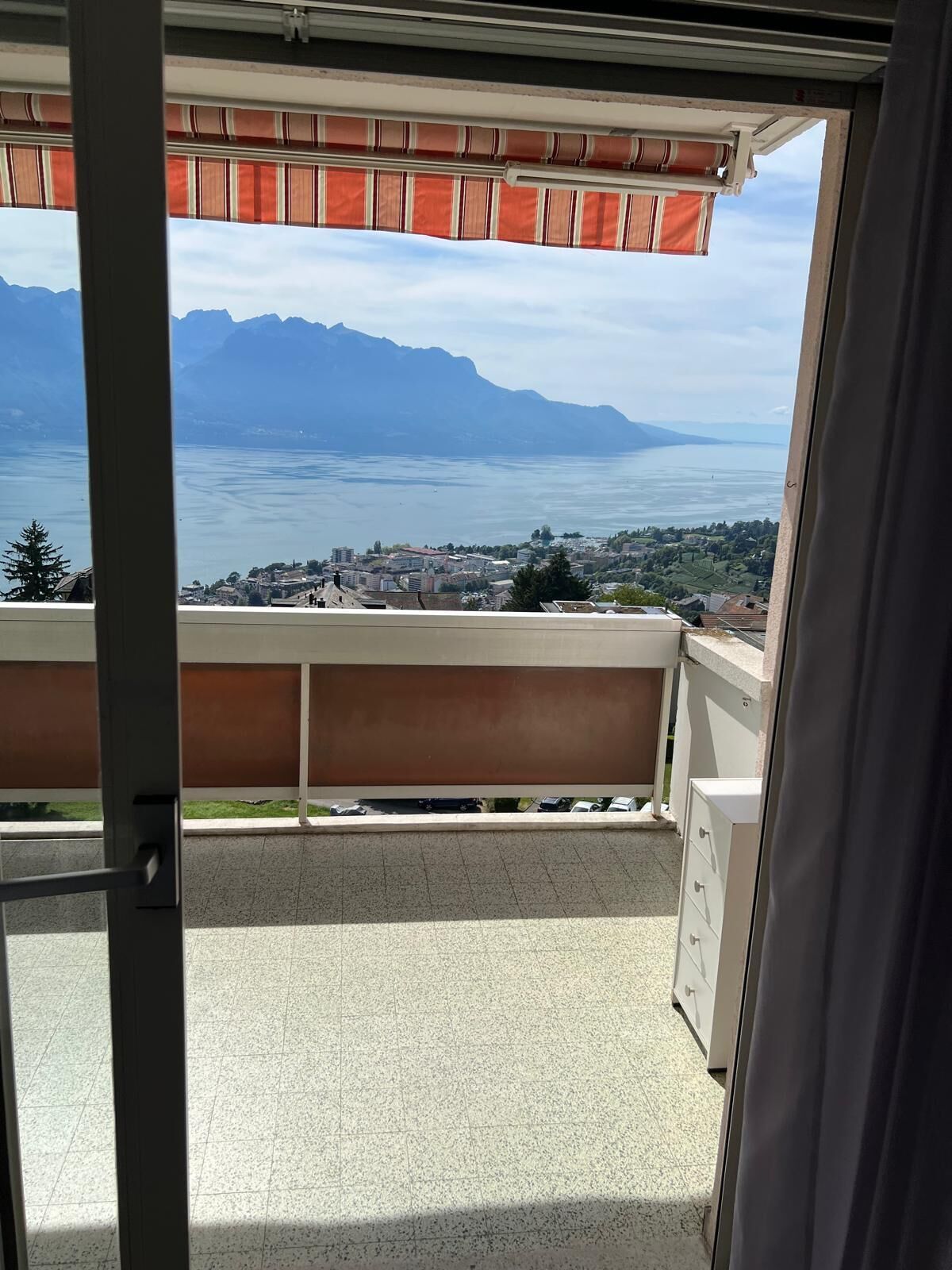 A balcony with a view of a lake and mountains.