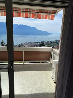 A balcony with a view of a lake and mountains.