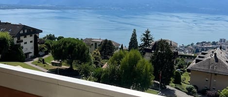 Varanda com vista para um lago e montanhas.