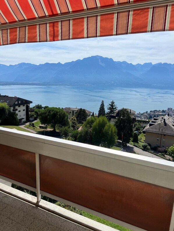 A balcony with a view of a lake and mountains.