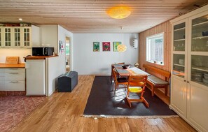 A compact kitchen with wooden cabinets, a dining area with a table and chairs, and a window providing natural light. - Cozy home in Stege with WiFi (Stege)