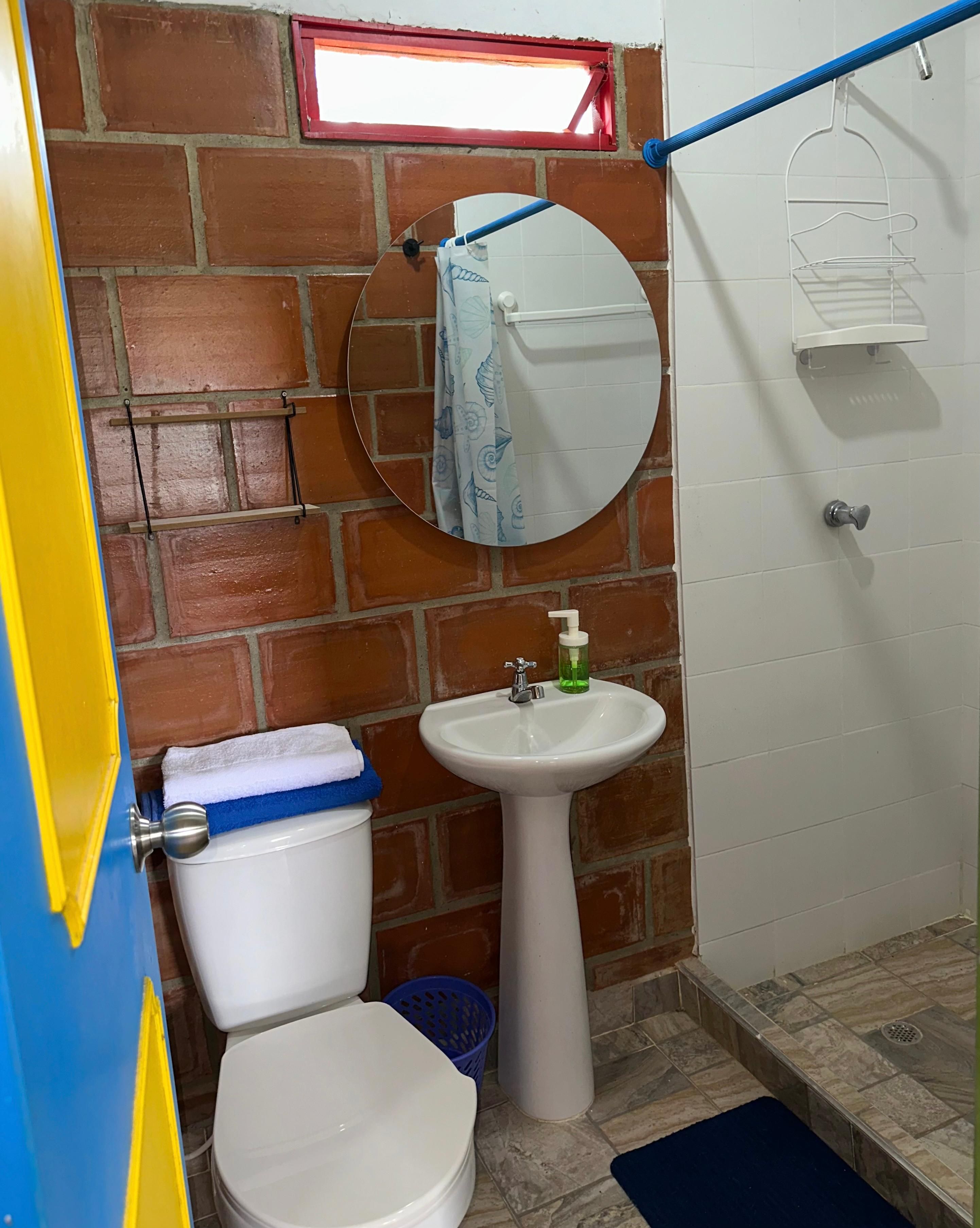 Un baño con inodoro, lavamanos y espejo.