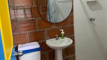 Un baño con inodoro, lavamanos y espejo.