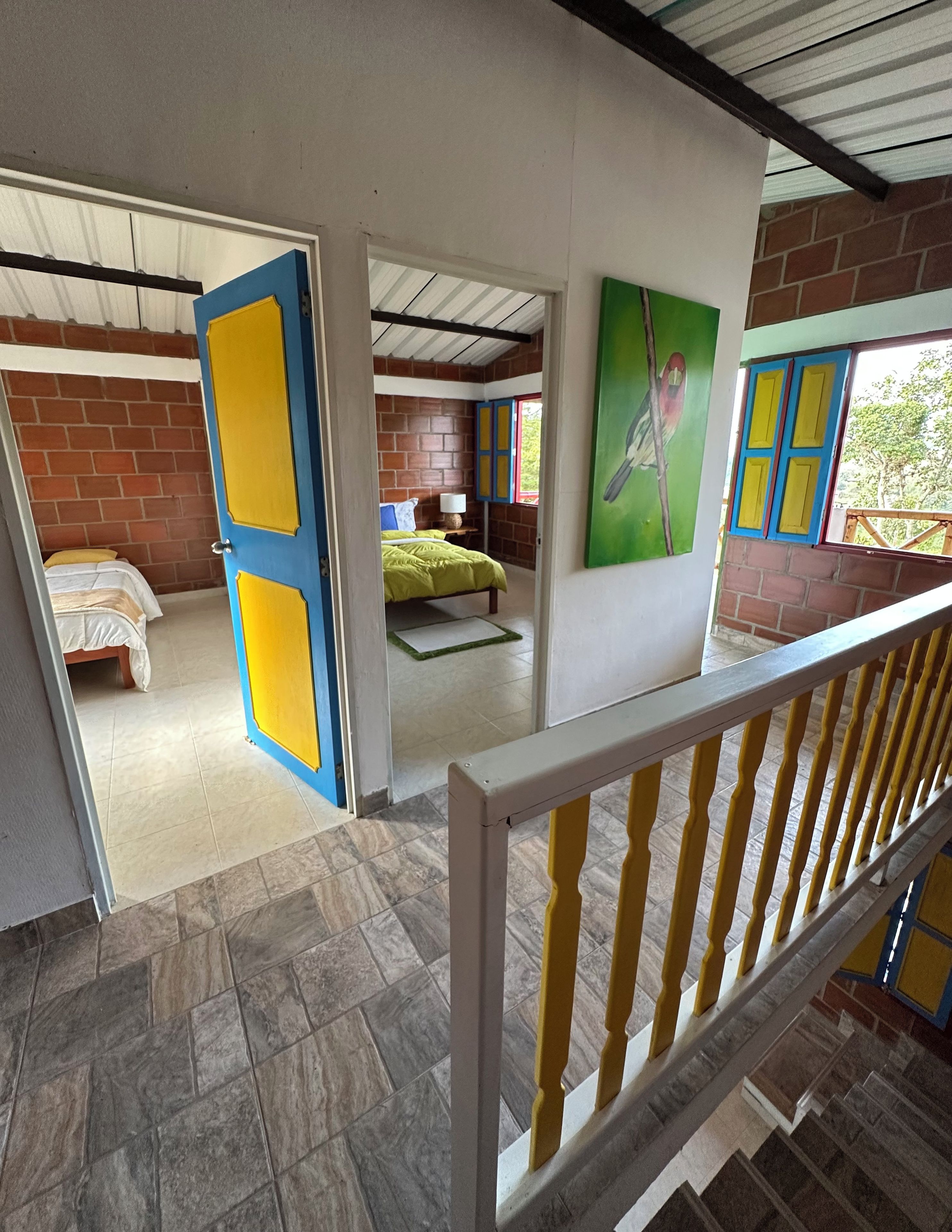 Een kamer met een bed, een raam met blauwe luiken en een groene wand.