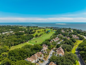 An aerial view of a residential area with houses, green spaces, and a golf course. - 3-Minute walk to beach, Screen porch, Seabrook Island Retreat - 751 Spinnaker (Seabrook Island)
