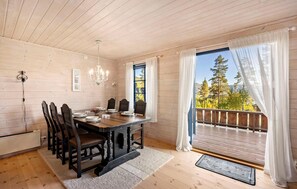Un coin repas avec une table en bois, des chaises et un lustre.