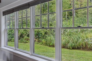 Une fenêtre donnant sur un jardin luxuriant et une pelouse verdoyante.