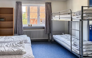 A dormitory room with bunk beds, a radiator, a window with curtains, and a bookshelf. - Nice home in ølgod with WiFi (Ølgod)