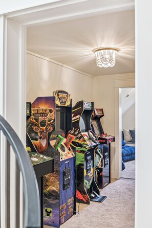 A room with arcade games and a chandelier. - Next to Sand Hill Frog Pool, Carriage House, Arcade Games - Lake District (Santa Rosa Beach)