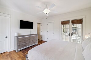 A bedroom with a bed, a dresser, a television, and a ceiling fan. - Next to Sand Hill Frog Pool, Carriage House, Arcade Games - Lake District (Santa Rosa Beach)