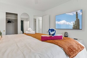 A hotel room with a bed, a TV, a painting, and a bathroom with a shower. - Scottsdale Retreat Home w/ Pool and Patio (Scottsdale)