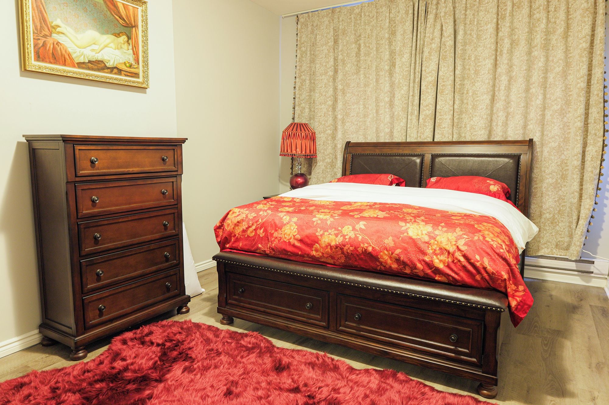 A bedroom with a wooden bed, a dresser, a red rug, and a painting on the wall.