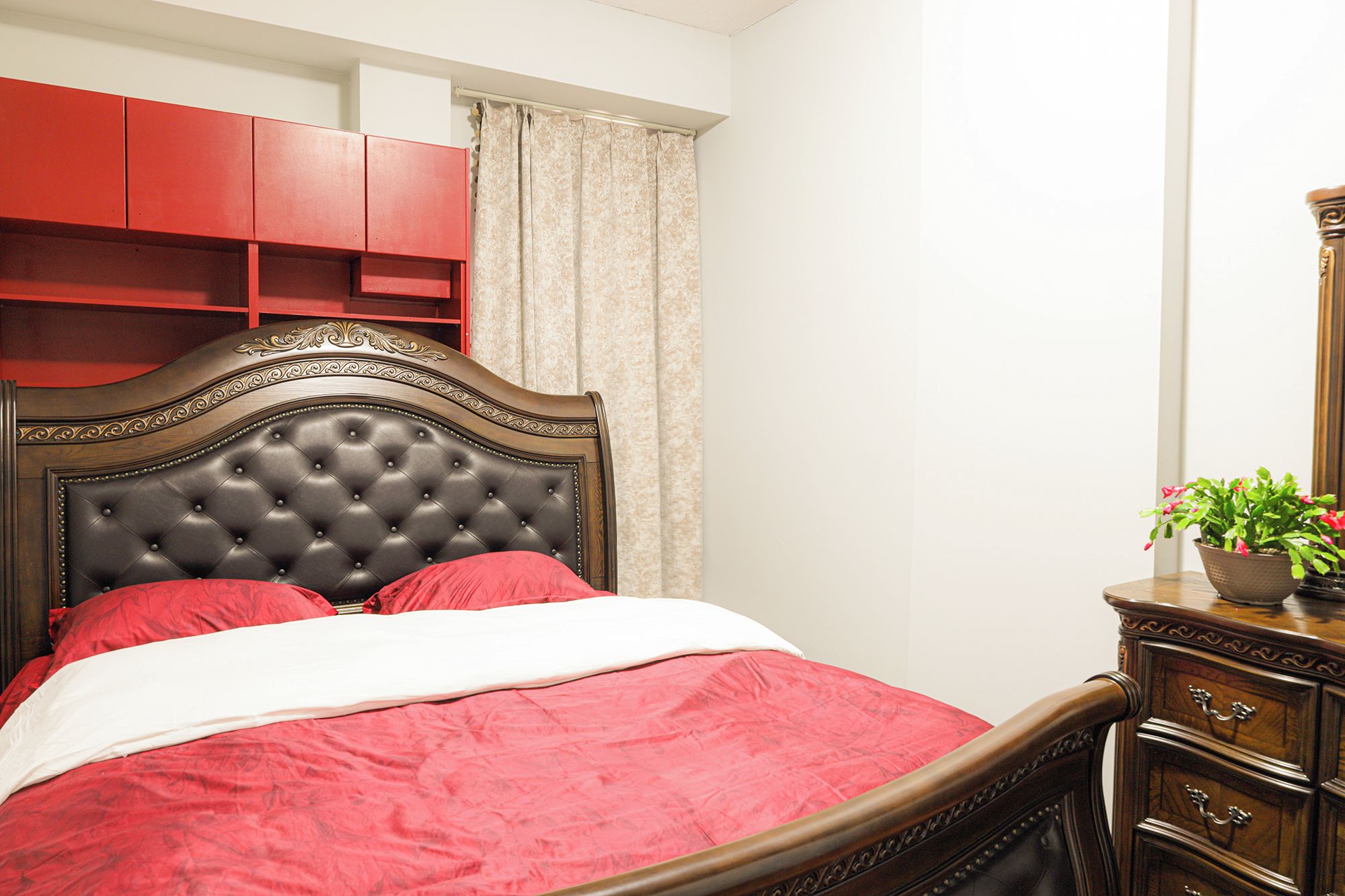 A bedroom with a bed, a dresser, and a mirror.