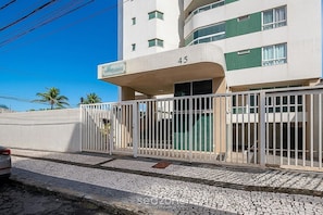 A modern building with a balcony, a gated entrance, and a tiled pavement. - Apt. w/ Balcony & Sea View in Condo. Buu0201 (Salvador)