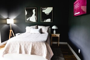 A bedroom with a bed, bedside tables, and wall art. - 3BR | Marathon | VA | Marshall (Huntington)