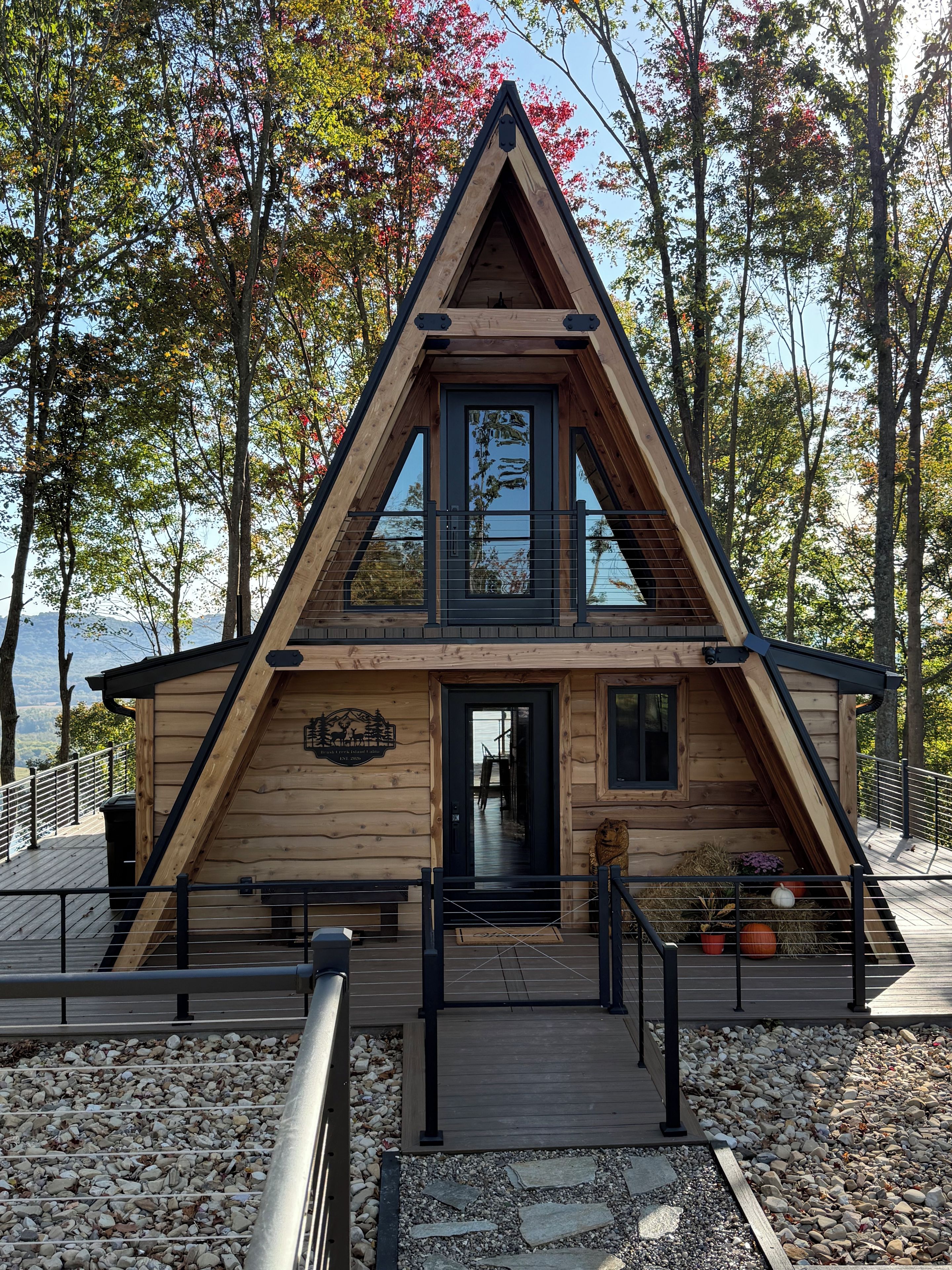 A wooden cabin with a triangular roof, a front door, and a small porch area.
