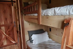Ein Schlafzimmer mit einem hölzernen Etagenbett, einem Holzschrank und einer Tür.