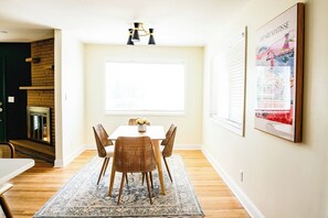 A dining area with a white table, four wicker chairs, a patterned rug, and a large window. - 3BR/2BA Barboursville, Near Mall, Parks, Marshall (Huntington)