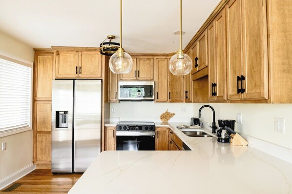 A kitchen with wooden cabinets, stainless steel appliances, and pendant lighting. - 3BR/2BA Barboursville, Near Mall, Parks, Marshall (Huntington)