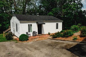 A small white single-story house with a front porch, a chimney, and a small garden area. - 2BR in Barboursville, Near Mall, Parks, & Marshall (Huntington)