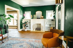 A room with a fireplace, a mirror, and a chair. - Charming 2BR Home - Marshall U & Local Attractions (Huntington)