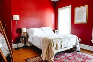 A bedroom with a bed, a floor lamp, a window, and a framed artwork on the wall. - Charming 2BR Home - Marshall U & Local Attractions (Huntington)