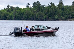 A boat with a Yamaha outboard motor, a person wearing a red cap, and another in a blue jacket.