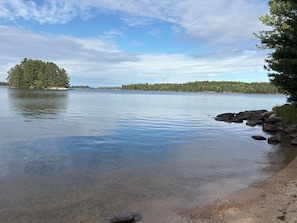 Un lac paisible avec une petite île et une rive rocheuse.
