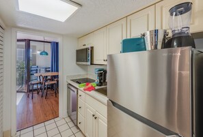 A compact kitchen with a refrigerator, microwave, and a blender. - Private 1 Bedroom Unit at Sand Dunes Villas (Myrtle Beach)