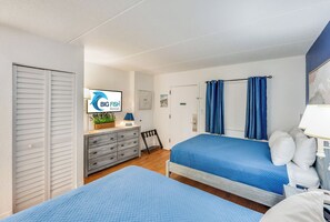 A bedroom with two beds, a dresser, a TV, and a door. - Private 1 Bedroom Unit at Sand Dunes Villas (Myrtle Beach)