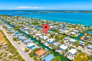 An aerial view of a coastal residential area with houses, a marina, and a bridge. - Hooked on Little Torch: 3BR Escape with 40' Dock, 15,000 lb Boat Lift & Elevator (Little Torch Key)